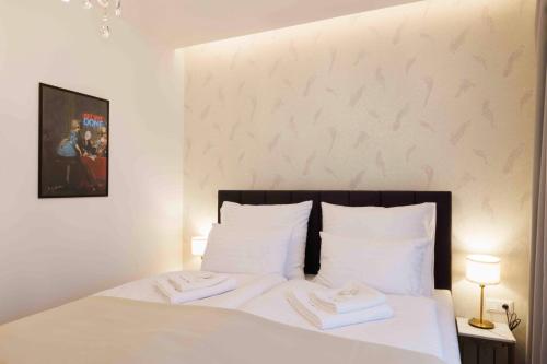 a bedroom with a white bed with two towels on it at Villa Mala Praha Experience in the Center of Žilina in Žilina