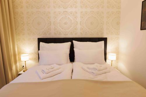 a bed with two towels on it with two lamps at Villa Mala Praha Experience in the Center of Žilina in Žilina