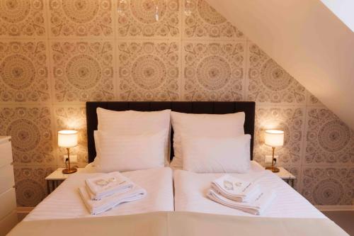 a bedroom with a bed with towels on it at Villa Mala Praha Experience in the Center of Žilina in Žilina