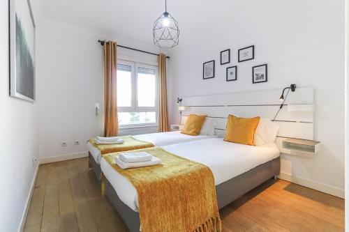 a bedroom with a large white bed with orange pillows at Laranjeiras Deluxe by Homing in Lisbon