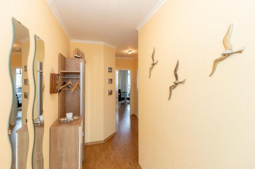 a hallway with birds hanging on the wall at Urlaubstraeume-am-Meer-Wohnung-4-11-9772 in Kühlungsborn