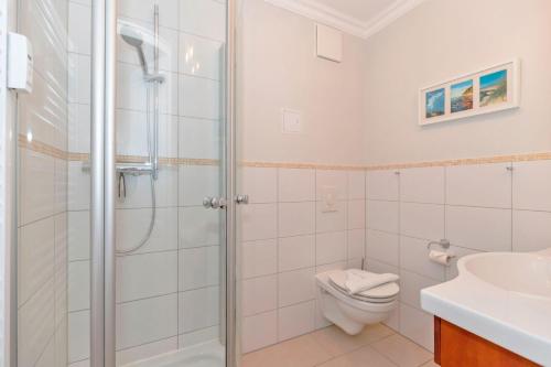 a bathroom with a shower and a toilet and a sink at Urlaubstraeume-am-Meer-Wohnung-5-3-539 in Kühlungsborn