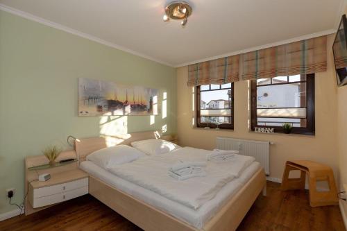 キュールングスボルンにあるUrlaubstraeume-am-Meer-Wohnung-4-7-649のベッドルーム1室(大きな白いベッド1台、窓2つ付)