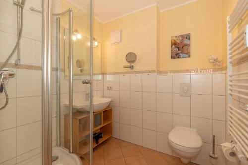 a bathroom with a shower and a toilet and a sink at Urlaubstraeume-am-Meer-Wohnung-4-7-649 in Kühlungsborn