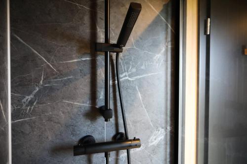 a shower with a blow dryer on a wall at Luxe Tinyhouse op minicamping in Waarde in Waarde