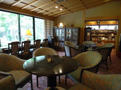 a restaurant with tables and chairs in a room at Kawakamiya Kasuitei in Gero