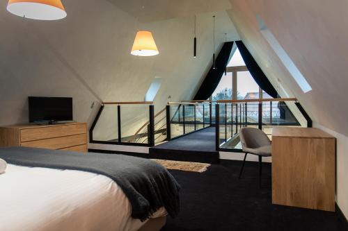 Habitación de hotel con cama y balcón en LES GITES DE LA KARLSMUHLE en Haguenau