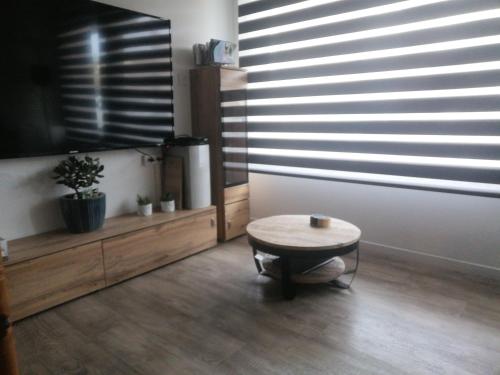 a living room with a table and a large window at Julie's Home in Bray-Dunes