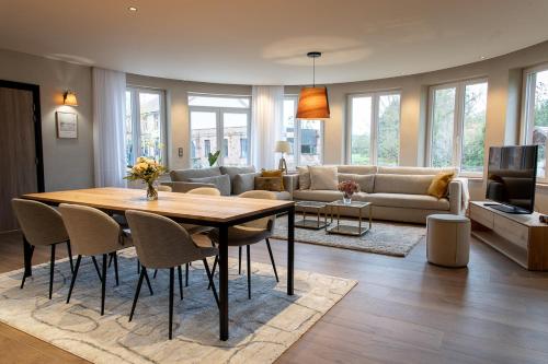 a living room with a table and a couch at LES GITES DE LA KARLSMUHLE in Haguenau