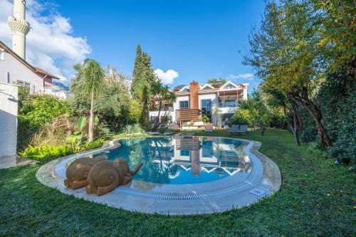 a swimming pool with two elephants statues in the yard at HEART DE MAISON in Kemer