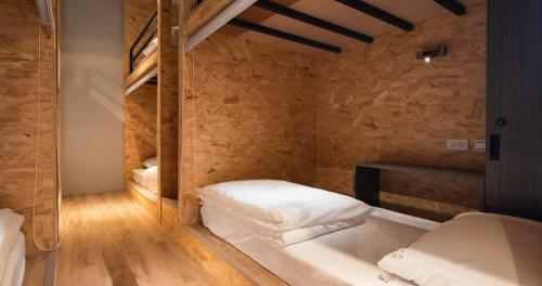 a bedroom with two beds and a wooden floor at 1954 Guest House in Taipei