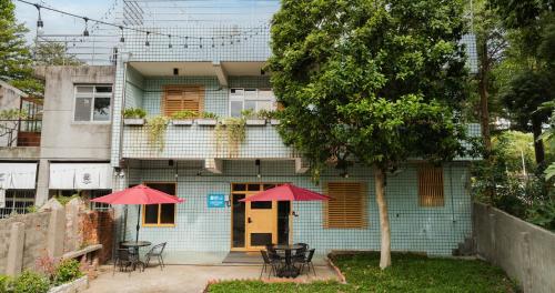 two red umbrellas in front of a blue house at 1954 Guest House in Taipei