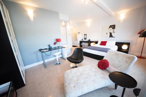 a bedroom with a bed and a couch and a desk at Days Inn by Wyndham Berthierville in Berthierville