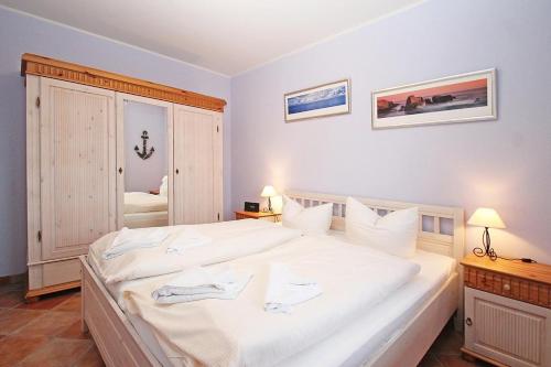 a bedroom with a large bed with white sheets at Urlaubstraeume-am-Meer-Wohnung-5-9-9609 in Kühlungsborn