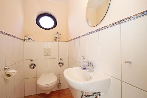 a bathroom with a sink and a toilet and a mirror at Urlaubstraeume-am-Meer-Wohnung-5-9-9609 in Kühlungsborn