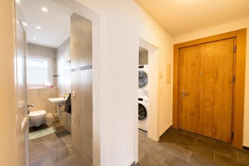 y baño con aseo, lavabo y lavadora. en Idyllic apartment in St. Moritz, en St. Moritz