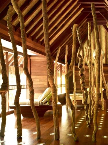 a room with a wooden ceiling with trees in it at Four Seasons Resort Bora Bora in Bora Bora