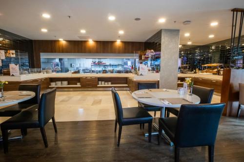 un restaurant avec deux tables et des chaises ainsi qu'une cuisine dans l'établissement Ramada Encore Istanbul Kartal, à Istanbul