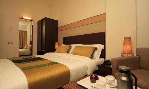 a hotel room with a bed and a table and a couch at FabHotel Prime Centurion in Pune