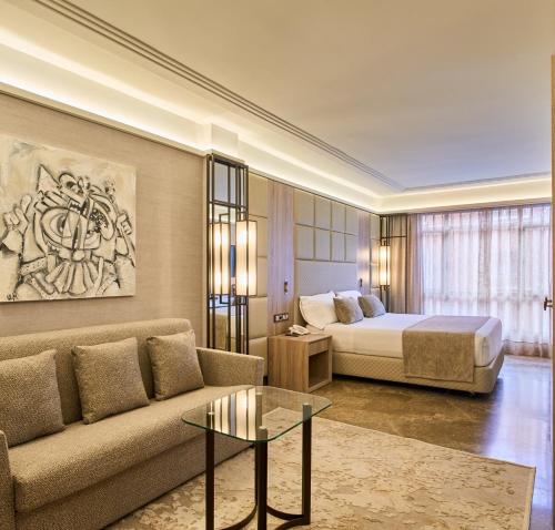 a hotel room with a bed and a couch and a table at VP Madroño in Madrid
