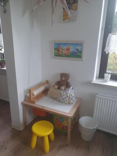 un escritorio de juguetes con un osito de peluche y un taburete en Familienfreundliche Ferienwohnung Erzgebirge en Schneeberg