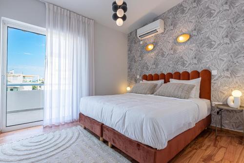 雅典的住宿－Phaedrus Living: Glyfada Seaview Luxury Penthouse，一间卧室设有一张大床和一个大窗户