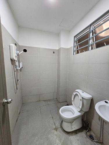 a bathroom with a toilet and a sink at 新裝潢三層連棟屋、寧靜寬敞舒適明亮、鄰近有大商場、大小陽台後院 in Penampang