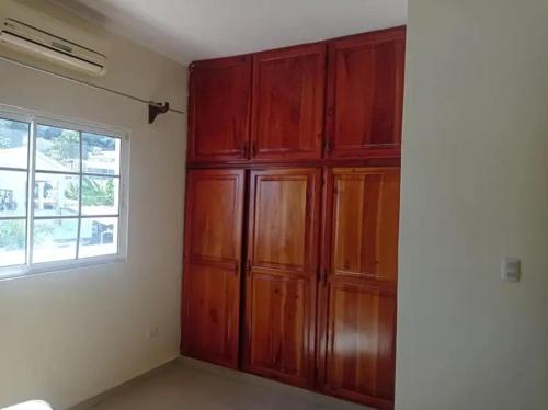 un gran armario de madera en una habitación con ventana en Habitación para descansar, en San Pedro Sula