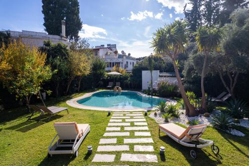 um quintal com uma piscina e duas espreguiçadeiras em HEART DE MAISON em Kemer