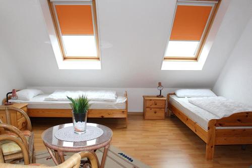 ニーンドルフにあるApartmentvermittlung Mehr als Meer - Objekt 52のベッド2台、テーブル、椅子が備わる客室です。