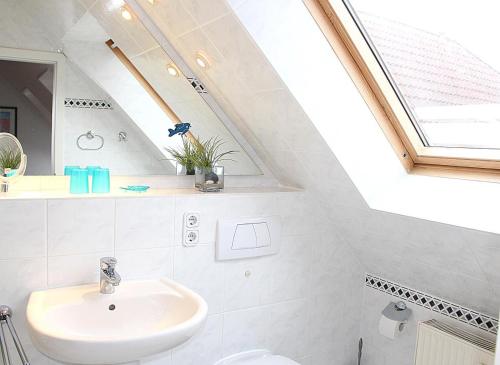 a bathroom with a sink and a skylight at Apartmentvermittlung Mehr als Meer - Objekt 52 in Niendorf