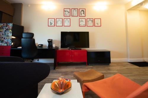 a living room with a tv and a red cabinet at Days Inn by Wyndham Berthierville in Berthierville