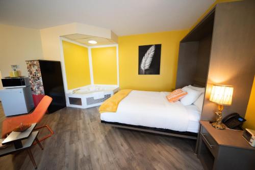 a bedroom with a bed and a bathroom with a tub at Days Inn by Wyndham Berthierville in Berthierville