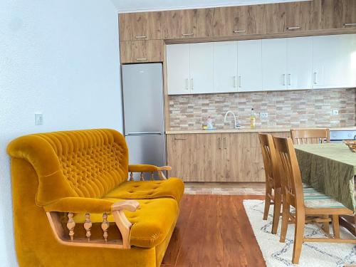 a kitchen with a yellow couch and a table at Apartment V&D in Berovo