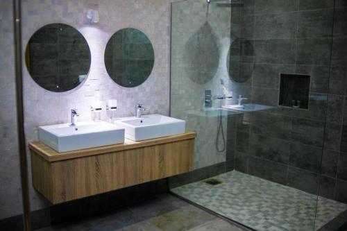 a bathroom with two sinks and a shower at Dozubel Hotel in Abuja
