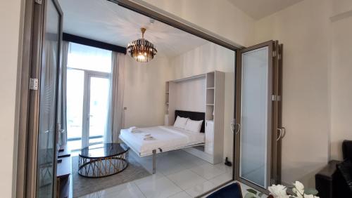 a bedroom with a bed and a glass door at Spacious, Economical Apt Near Miralcz Garden in Dubai