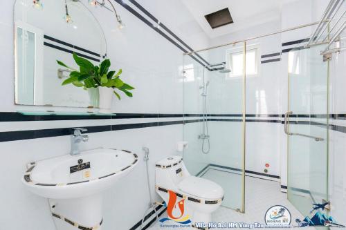een witte badkamer met een toilet en een wastafel bij Biệt Thự ĐĂNG KHOA Hồ Bơi Bida karaoke in Vung Tau