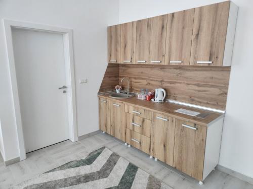 a kitchen with wooden cabinets and a sink at Hotel Balon in Velika Kladuša