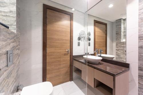 Łazienka z drewnianymi drzwiami i umywalką w obiekcie Spacious 3BR Apartment Near Miracle Garden w Dubaju