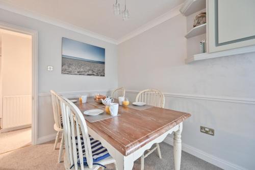 a dining room with a wooden table and chairs at Top Floor Sandbanks Apartment with Free Parking just minutes from the Beach and Bars in Canford Cliffs