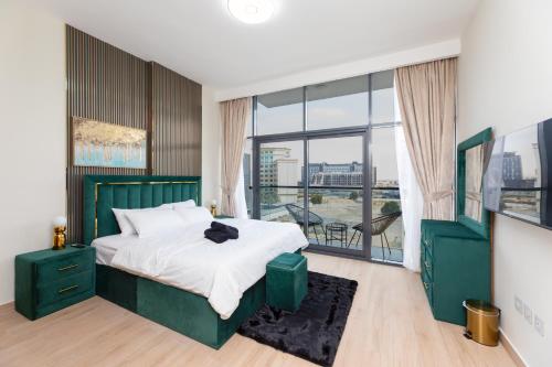 a bedroom with a green bed and a large window at Spacious 3BR Apartment Near Miracle Garden in Dubai
