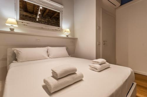 Un dormitorio con una cama blanca con toallas. en Veronetta The Cellar en Verona