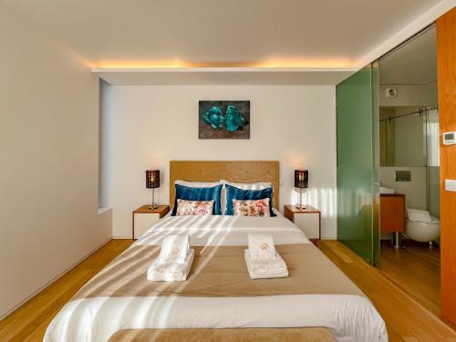 - une chambre avec un grand lit et 2 serviettes dans l'établissement Casa do Trigo - with garage in the city center, à Viana do Castelo