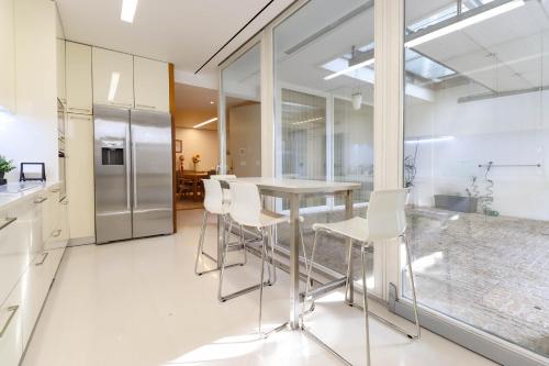 a kitchen with a table and white chairs at Casa do Trigo - with garage in the city center in Viana do Castelo