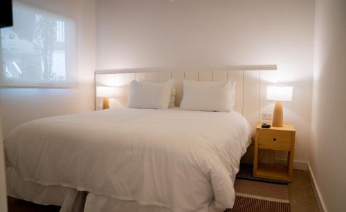 a bedroom with a large white bed and a window at Casagrande Hotel & Beach Club in José Ignacio