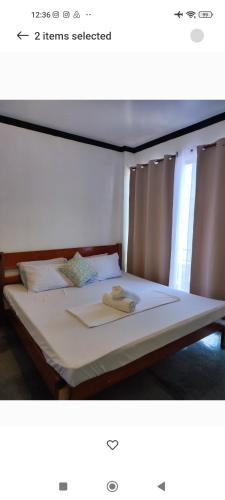 a bedroom with a large bed with white sheets at Hidden Gem Siargao in General Luna