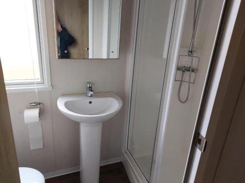 a white bathroom with a sink and a shower at 208 Holiday Resort Unity Brean 3 bed entertainment passes included in Brean