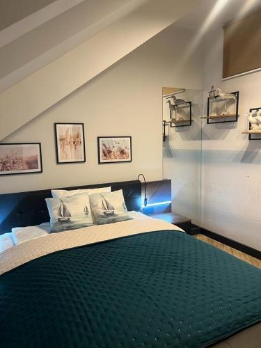 a bedroom with a large bed with a green blanket at Apartamenty Terminal Charzykowy in Charzykowy