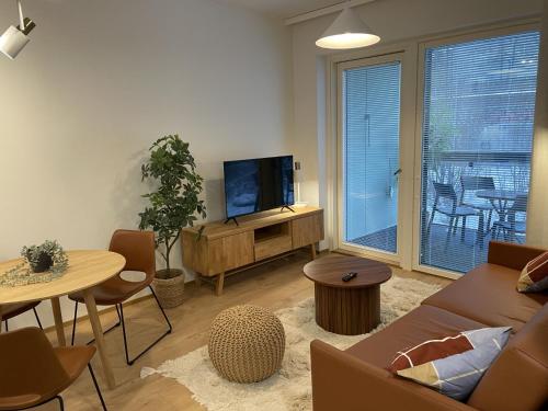 a living room with a couch and a tv and a table at Kodikas kaksio lähellä keskustaa in Tampere