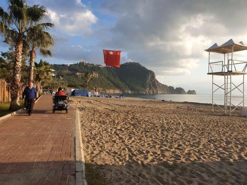 una persona in bicicletta su una spiaggia con una persona che cavalca un passeggino di SunStar Kleopatra beach a Alanya